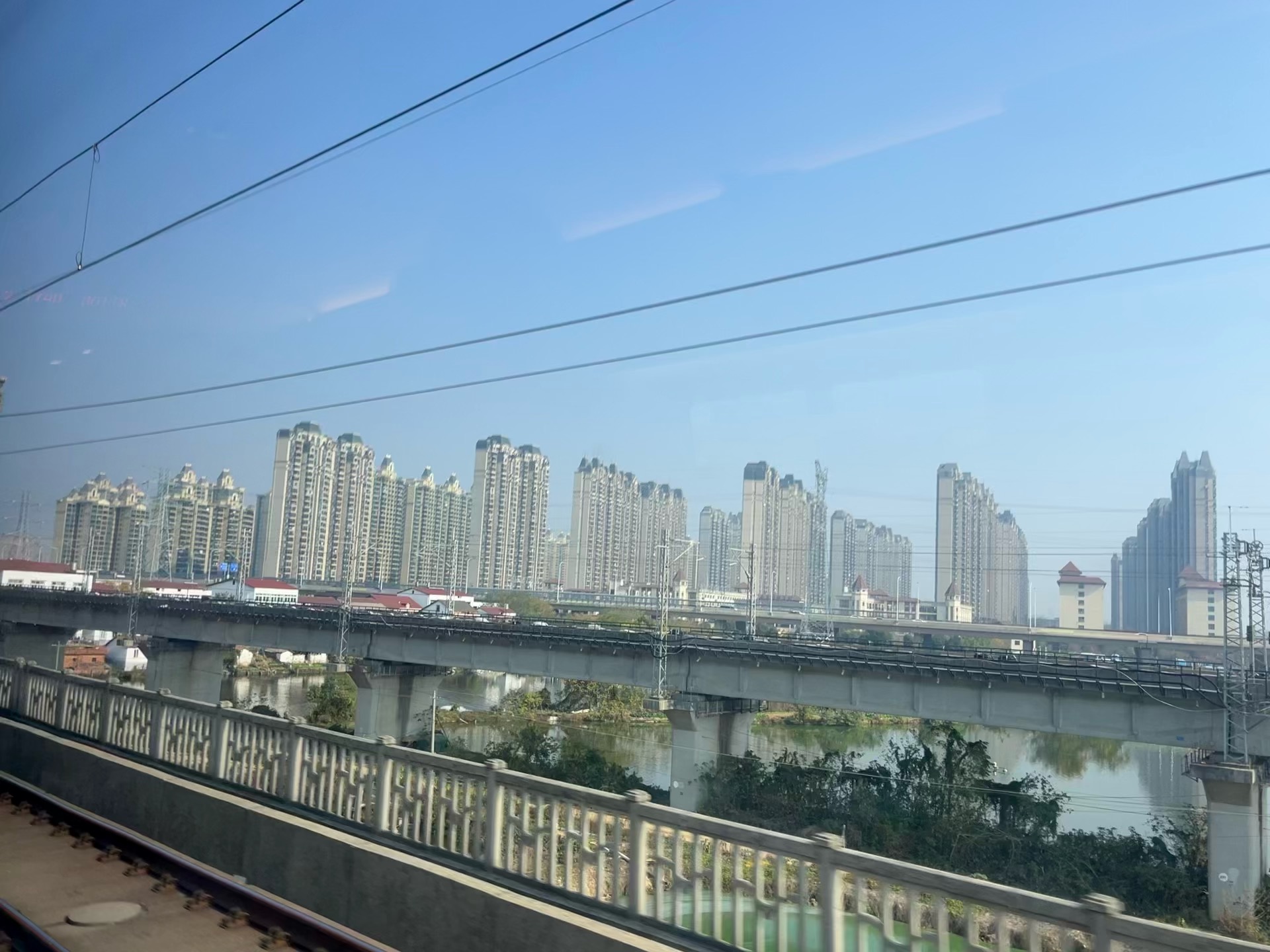 View from the train window showing cityscape and river